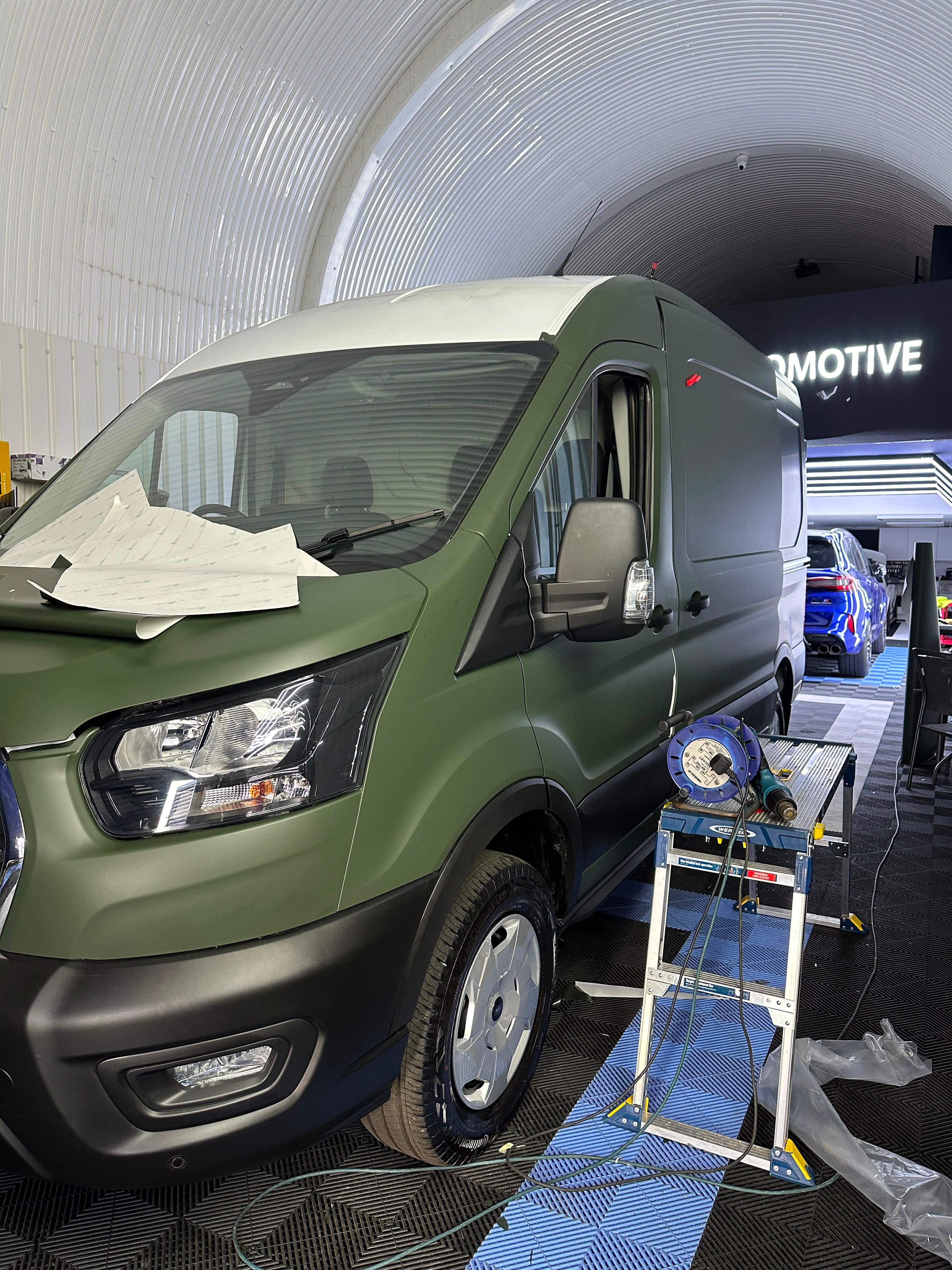 Olive wrap going onto a Ford Transit, heat gun on the ladder