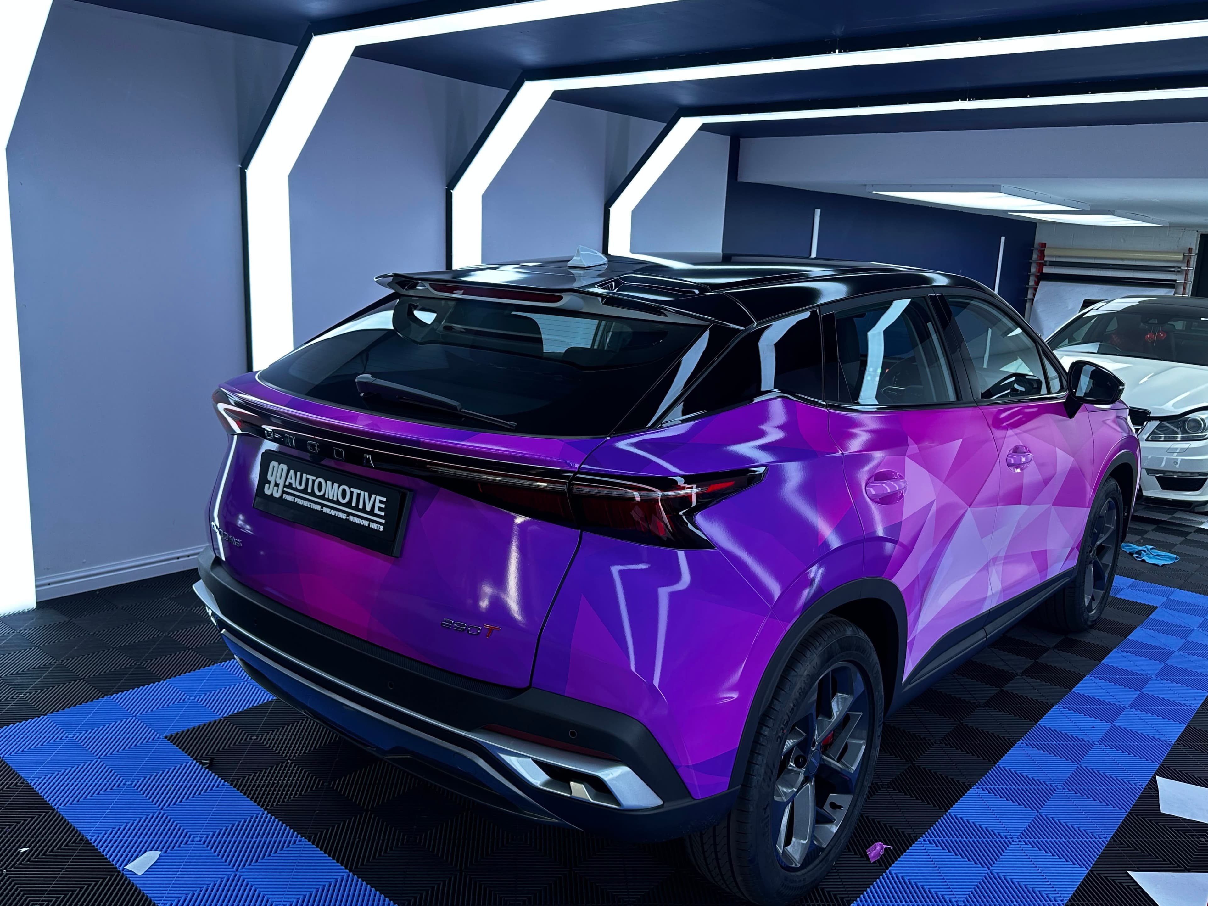Purple geometric wrap on an Omoda 5 in the light rig