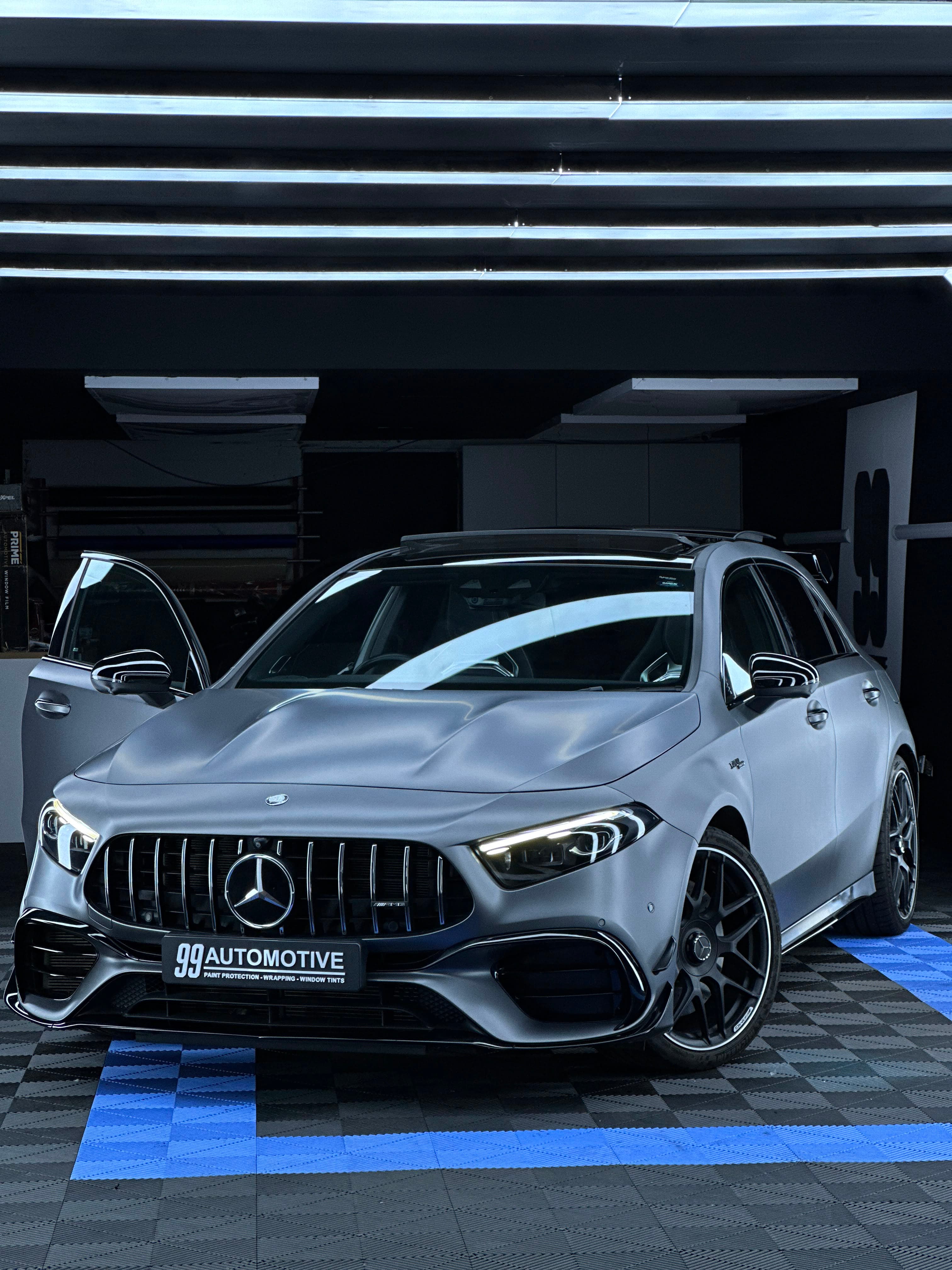 Matte grey Mercedes-AMG A45 S, door open in the bay