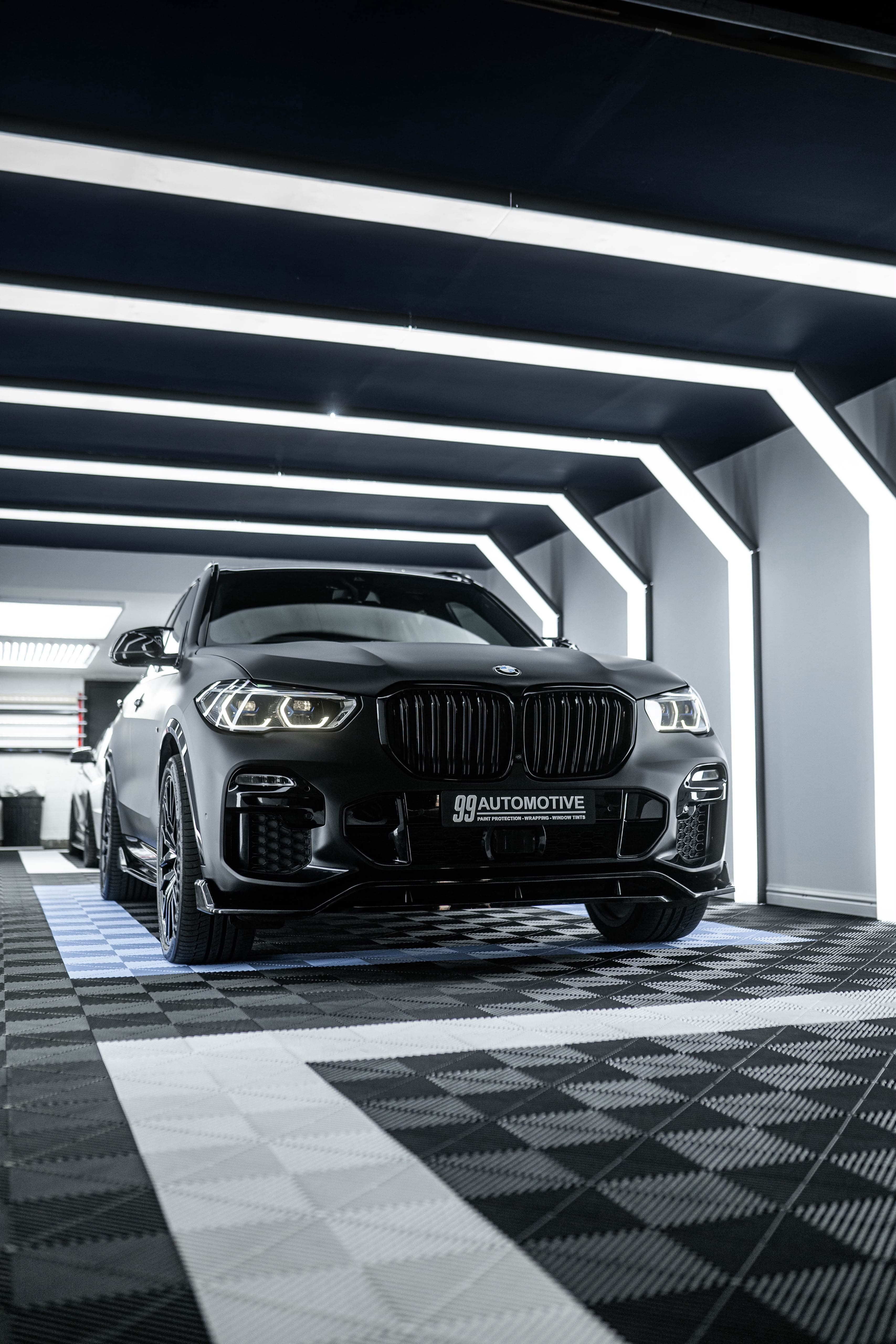 Matte black BMW SUV, low front three-quarter